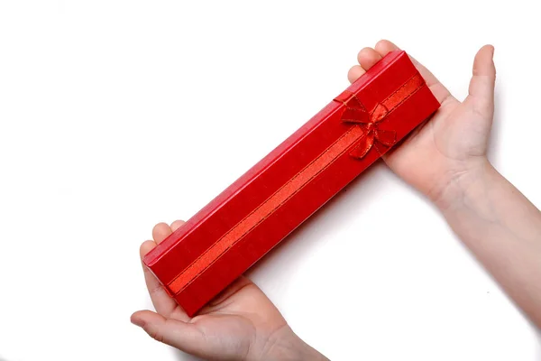 Manos de bebé sosteniendo una caja de regalo roja aislada sobre un fondo blanco — Foto de Stock