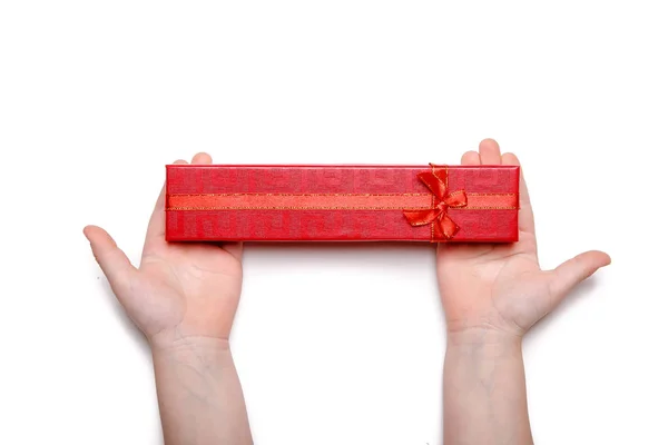 Дитячі руки тримають червону подарункову коробку ізольовано на білому тлі — стокове фото