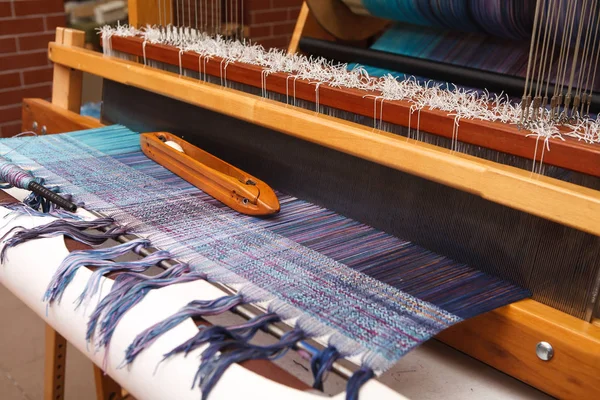 Weaving shuttle on the blue warp in weaving machine — Stock Photo, Image