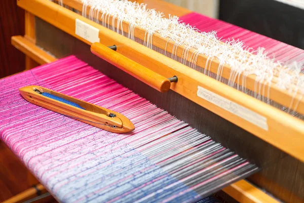 Transbordador de tejido en la urdimbre de color en la máquina de tejer — Foto de Stock