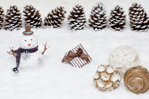 Подарочная коробка и снеговик в снегу . — стоковое фото