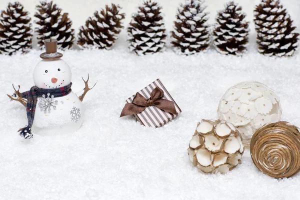 Подарочная коробка и снеговик в снегу . — стоковое фото