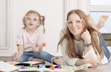 Kızı ve annesi yere oturup çizmek. 