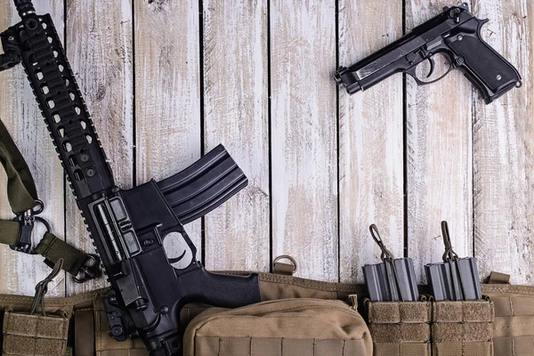 Espingarda, arma e cinto do exército com munição na mesa — Fotografia de Stock