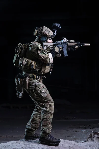 Солдат целился из винтовки на темном фоне — стоковое фото