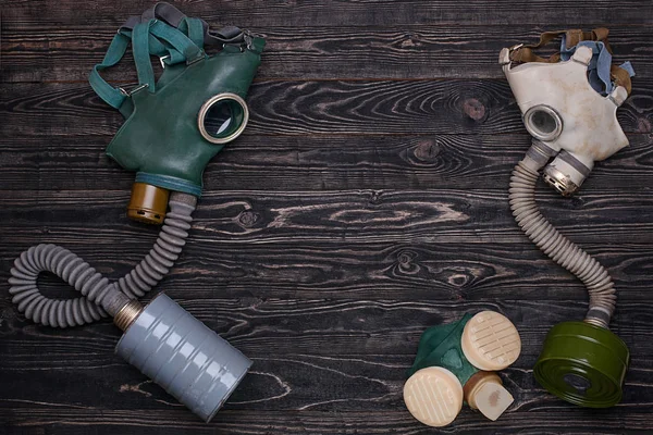 Two gas mask and respirator on dark wooden background — Stock Photo, Image