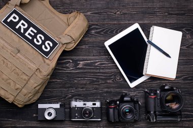 Tablet PC ve dizüstü bilgisayar, vücut zırh ve ahşap masa üzerinde kameralar fotoğraf