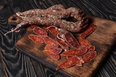 İtalyan sosis kesme tahtası üzerinde dilimlenmiş. Seçici odak