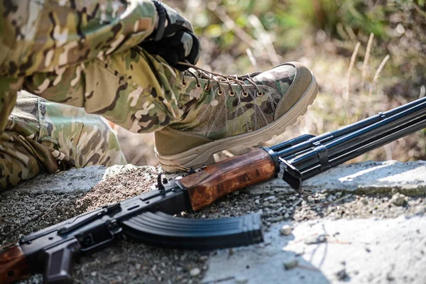 Hands in gloves tie the shoelaces.Selective focus/Men\'s hands in dark gloves tie laces on military boots