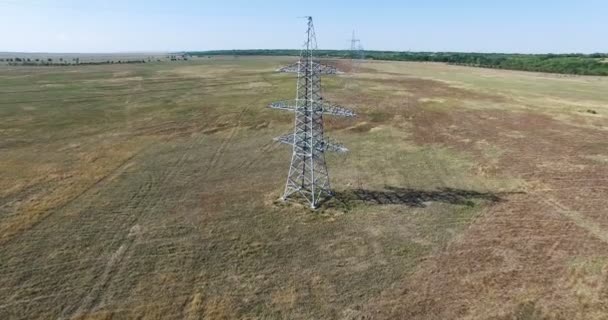 Luchtfoto: Opvliegende de hoogspanning elektriciteit toren en hoogspanningsleidingen. Luchtfoto drone schoot. 4k 30fps — Stockvideo