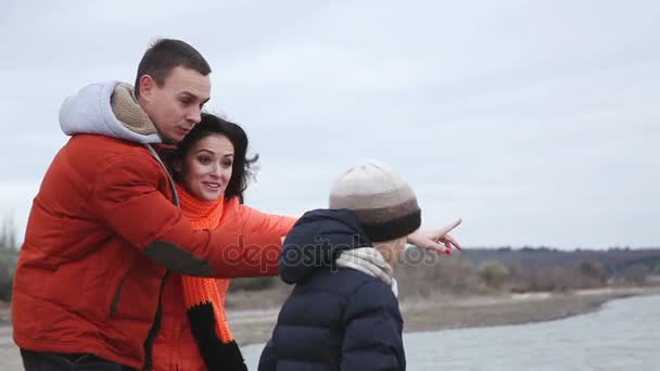 Fishing boy catches fish. Mom and dad are helping to get the fish out of the lake. — Stock Video