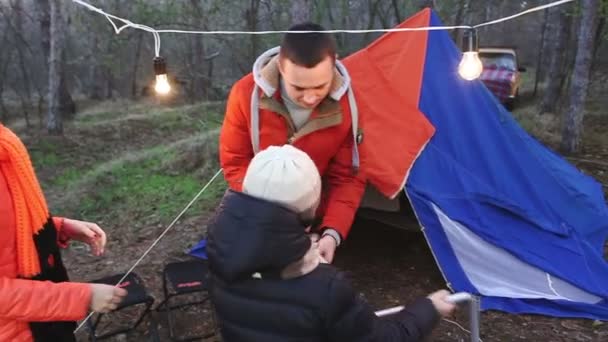 Herbstwald, die Familie baut das Zelt auf. — Stockvideo