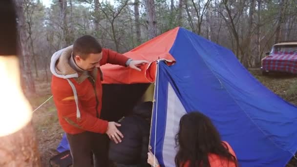 23. Young family sets the tent, in the evening in the forest. Burning light bulb. — Stock Video