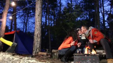Mutlu aile sosis ormanda kamp ateşi üzerinde pişiriyor. Serisi.