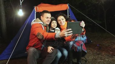 Genç mutlu aile çadırı arka plan üzerinde ormandaki selfie yapar.