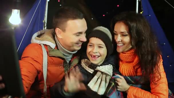 Jonge gelukkige familie maakt selfie in het bos op de achtergrond van de tent. — Stockvideo