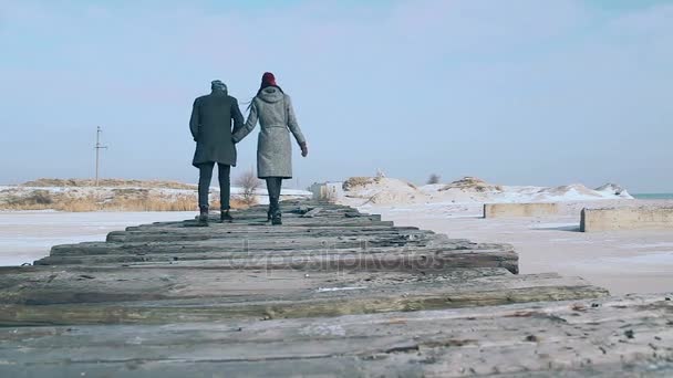 Aktivt par promenader på bron av plankor, en vacker solig vinterdag. — Stockvideo