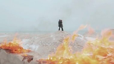 Ateşe Kum tepesi çerçevede bir çift ayakta. Kış deniz.