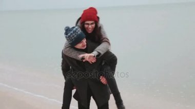 Genç çift sahilde oynarken. Adam ve kız koşuşturma.