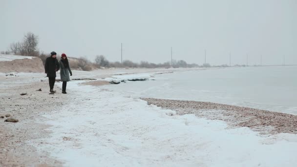 Пара ходить на пляжі тримаючи руки, посміхаючись, розмовляючи . — стокове відео