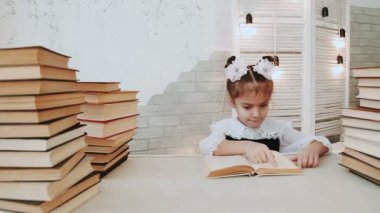Bir masada oturan ve bir kitap okuma kız öğrenci.