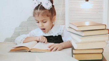Bir tablo ve okuma oturan kız öğrenci bu esner okuma sırasında bir kitap.