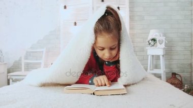 Pijama, kitap okuyarak şirin liseli kız portresi kaplanmış beyaz yün battaniye ile.