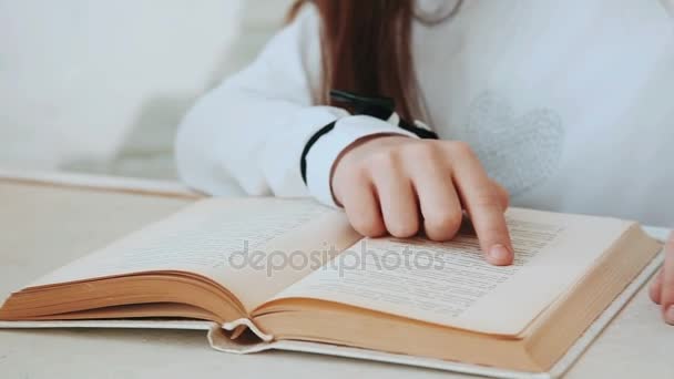 La mano di una bambina conduce la pagina del libro . — Video Stock