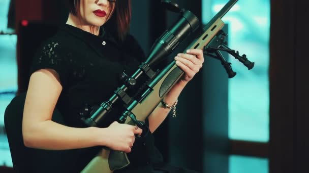 Het meisje met een agressieve look met een sniper rifle. — Stockvideo