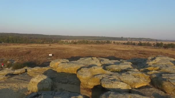 Un homme engagé dans la gymnastique chinoise, sur les rochers. Aérien .