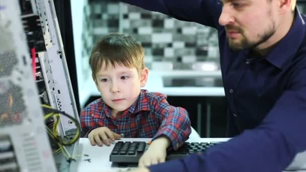 Vater und Sohn reparieren einen Computer. — Stockvideo