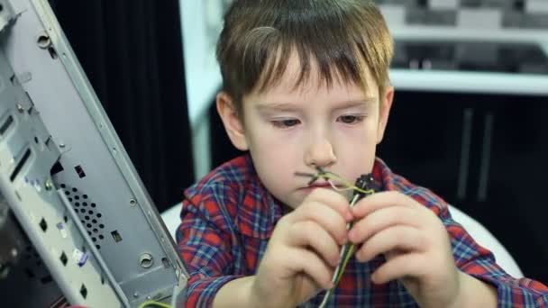 Un niño pequeño reparar una computadora . — Vídeos de Stock