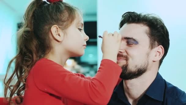 Dotter göra make-up till hennes pappa. — Stockvideo