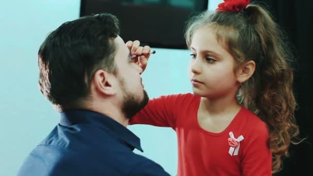 Dotter göra make-up till hennes pappa. — Stockvideo