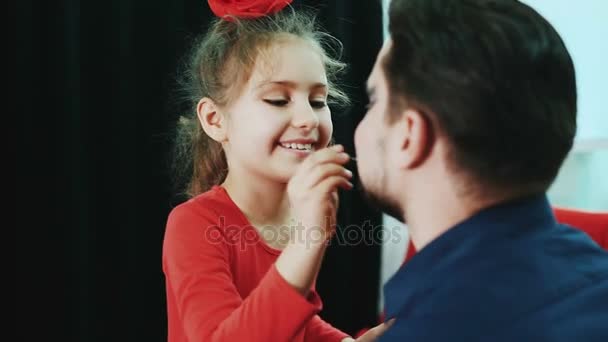 Смішна сім'я. Батько і його дочка дівчина малює губи батькові . — стокове відео
