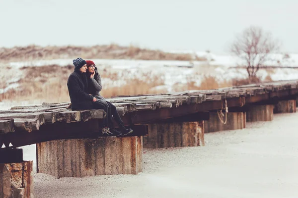 Genç adam ve kız kış giyim, kucaklamak ve kış sahne tadını çıkarın.