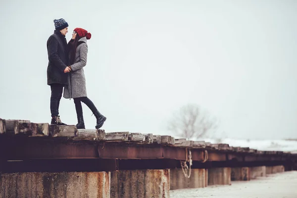 Genç adam ve kız kış giyim, kucaklamak ve kış sahne tadını çıkarın.