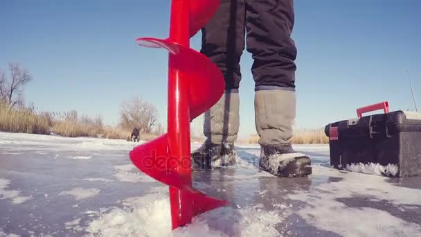 Soğuk buz ve yapmak bir delik balık için Ice buz matkap geçer. buz balıkçılık. — Stok video