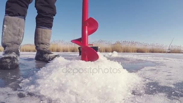 Soğuk buz ve yapmak bir delik balık için Ice buz matkap geçer. buz balıkçılık. — Stok video