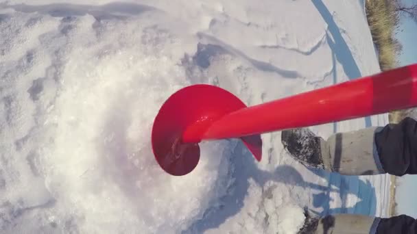 Eisbohrer gehen durch das kalte Eis und machen ein Loch für das Eisfischen. Eisfischen. — Stockvideo