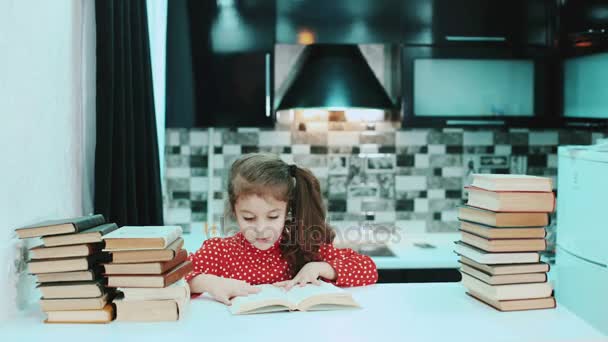 Mädchen liest ein Buch in der Küche. Schnelles Spiel. Taymlaps. — Stockvideo