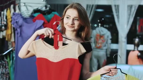 Mulher bonita escolher entre dois vestidos — Vídeo de Stock