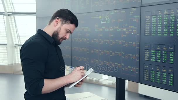 A young power engineer near the electronic data panel. — Stock Video