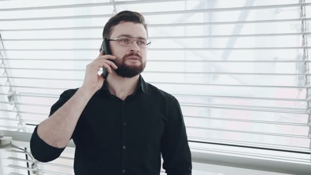 Joven empresario mirando por la ventana — Vídeo de stock