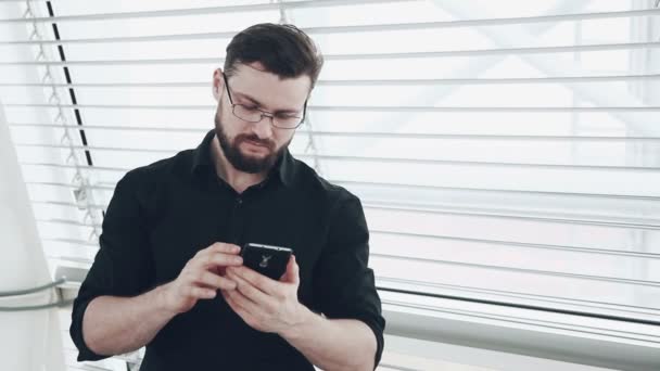Молодой бизнесмен со смартфоном — стоковое видео