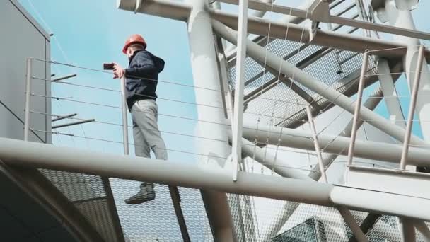 Ingeniero hace selfie en el teléfono en el objeto industrial — Vídeos de Stock