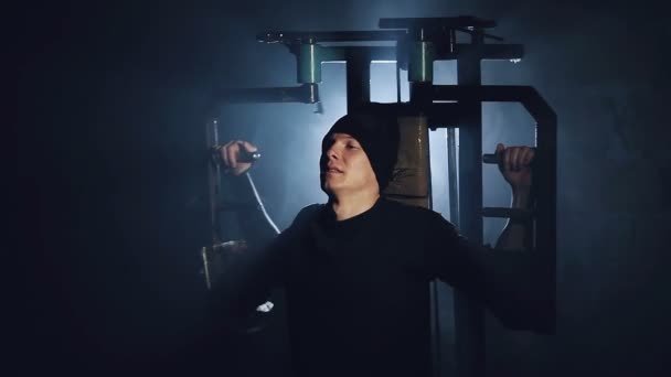 Мужчина накачивает мышцы на тренажере в спортзале крупным планом — стоковое видео