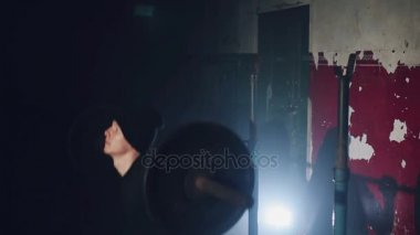 Kaslı adam CrossFit eğitimi spor salonunda ağırlık mı bel düzeyinde bir sağlık ve fitness kavramı, hareket yakın çekim yuvarlak bir halter tutan bir koyu gölgeli.