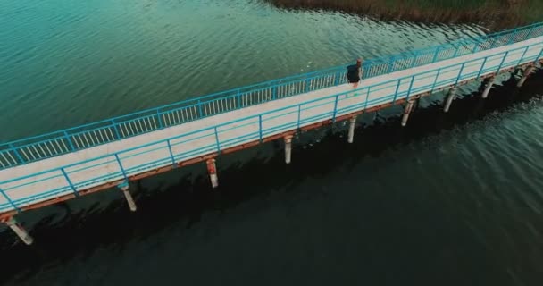 Jovem caminhando na ponte de madeira — Vídeo de Stock