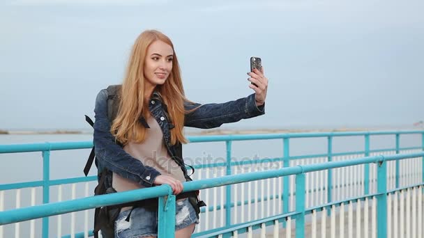 Όμορφο κορίτσι κάνει selfies στέκεται δίπλα στο ποτάμι — Αρχείο Βίντεο